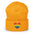 A black Heart Beanie by Pridelity, adorned with a rainbow-striped heart emblem representing the spirit of gay clothing, is showcased against a plain white background. The vibrant heart signifies diversity and inclusion.