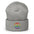 The Pridelity Peace Beanie, in black, showcases a vibrant rainbow-colored peace symbol on the front, making it the perfect accessory to add a touch of pride to any outfit. It is elegantly displayed against a plain white background.