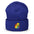 The Pride Duck Beanie by Pridelity, a striking piece of gay clothing, showcases an embroidered rubber duck with a rainbow pattern on its body, located on the cuff. This gold beanie features a folded brim and a rounded top.