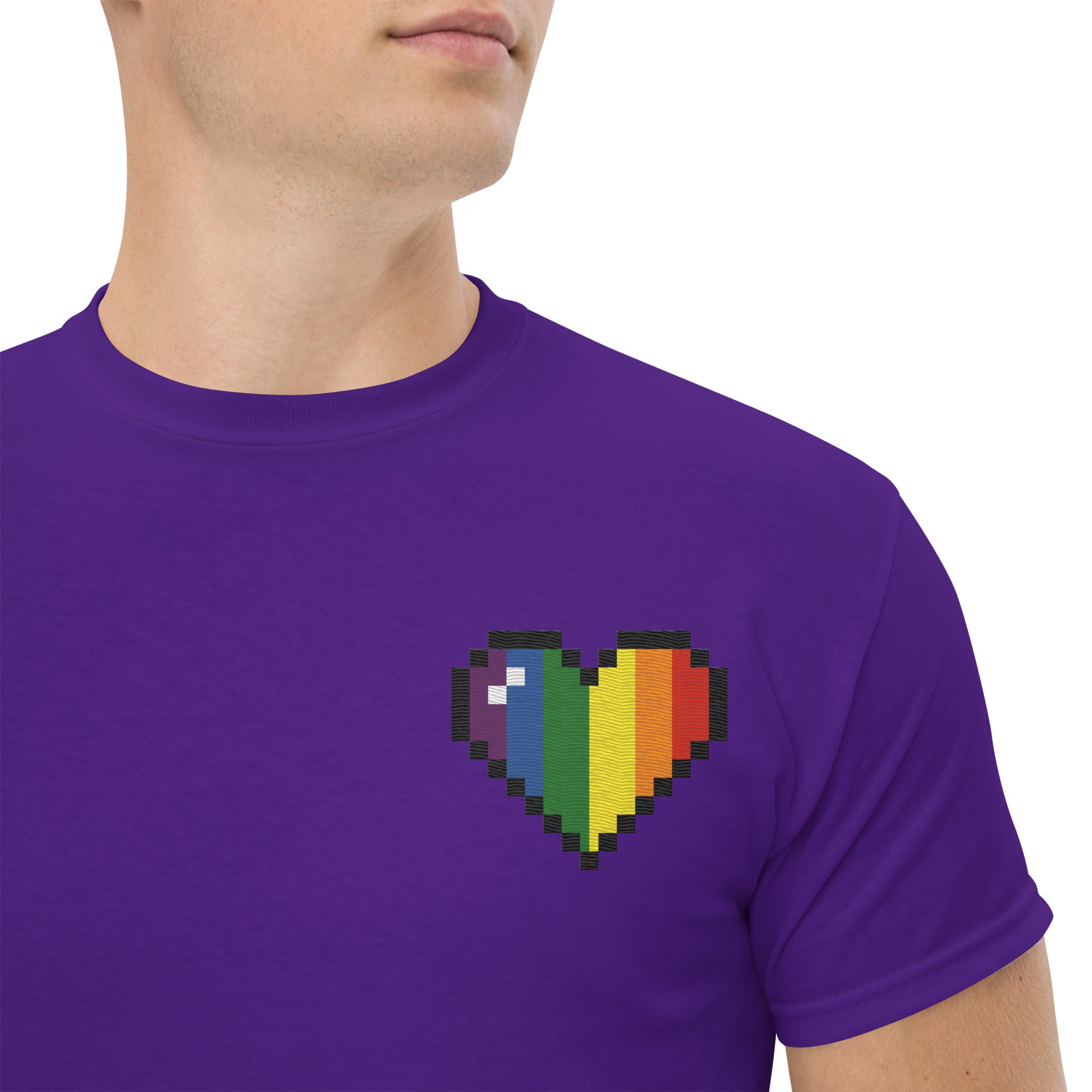 The Pixel Heart T-Shirt by Pridelity is a white shirt featuring a pixelated heart design in the upper left corner, with vertical sections of vibrant colors: black, brown, red, orange, yellow, green, blue, and purple.