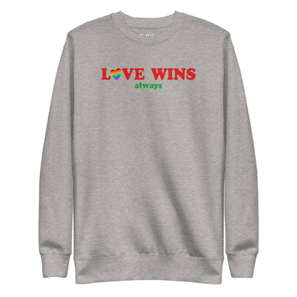 Introducing the "Love Wins, Always Sweatshirt" by Pridelity. This white sweatshirt prominently displays the bold red and green phrase "LOVE WINS always," with a unique twist: the "O" in "LOVE" is crafted into a vibrant rainbow-colored heart. It’s an ideal choice for anyone who embraces love with rainbow-inspired apparel.