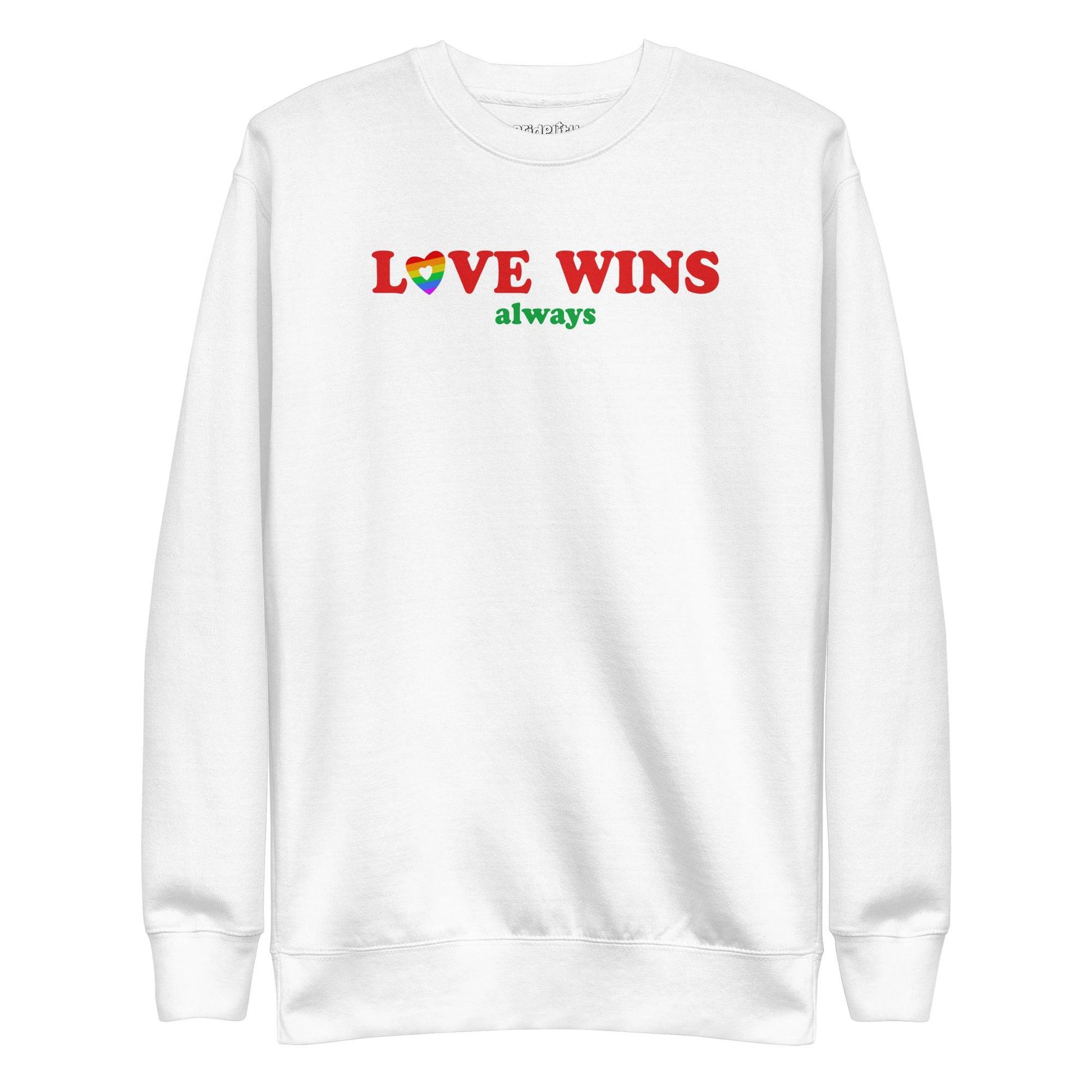 Introducing the "Love Wins, Always Sweatshirt" by Pridelity. This white sweatshirt prominently displays the bold red and green phrase "LOVE WINS always," with a unique twist: the "O" in "LOVE" is crafted into a vibrant rainbow-colored heart. It’s an ideal choice for anyone who embraces love with rainbow-inspired apparel.